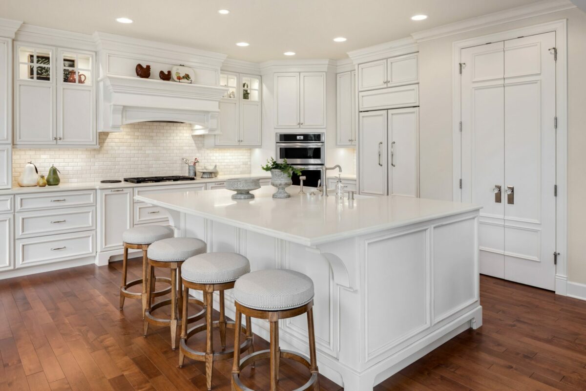 Beautiful kitchen in new traditional style luxury home, with large island, double ovens, cook top, and open concept floor plan