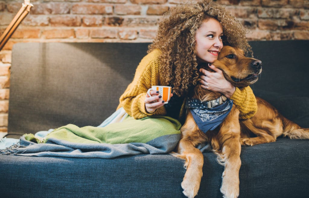 Woman playing with her dogs at home.