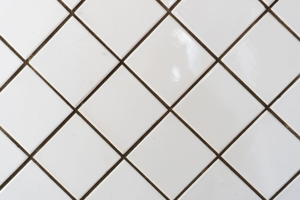 Close-up of white tiles arranged in a diagonal layout, creating an artistic twist on a classic design with a dynamic, modern appeal