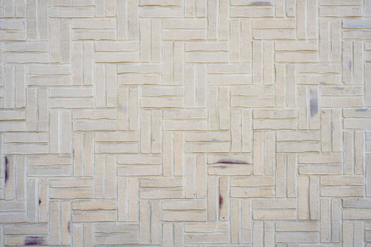 Close-up of a basket weave tile layout with beige textured tiles, creating a vintage charm with interlocking rectangular patterns for a timeless design