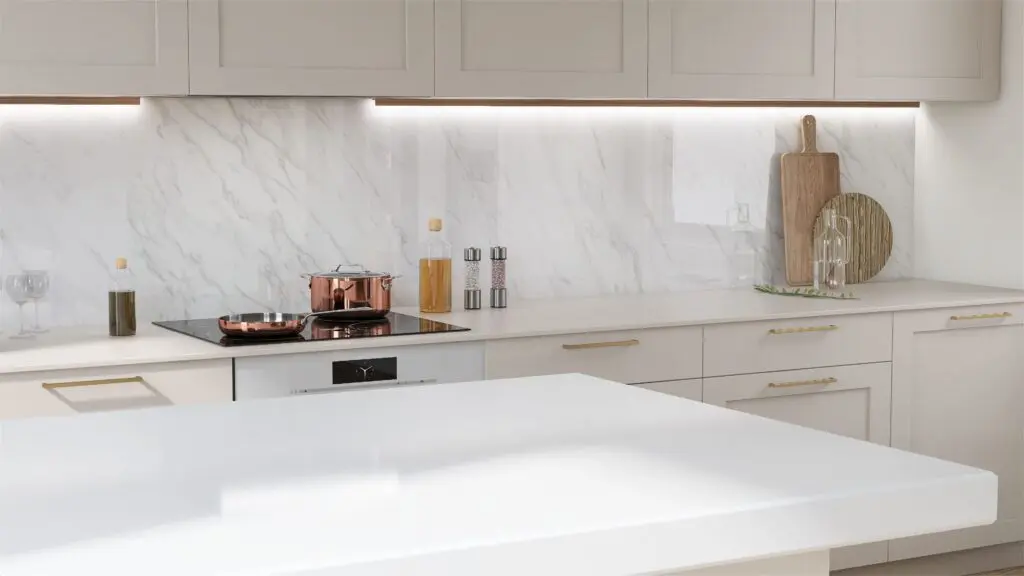 Modern kitchen with light-colored cabinets, marble backsplash, and white countertops. A copper pot sits on a stovetop, with salt and pepper mills, oil bottles, and cutting boards arranged neatly nearby.