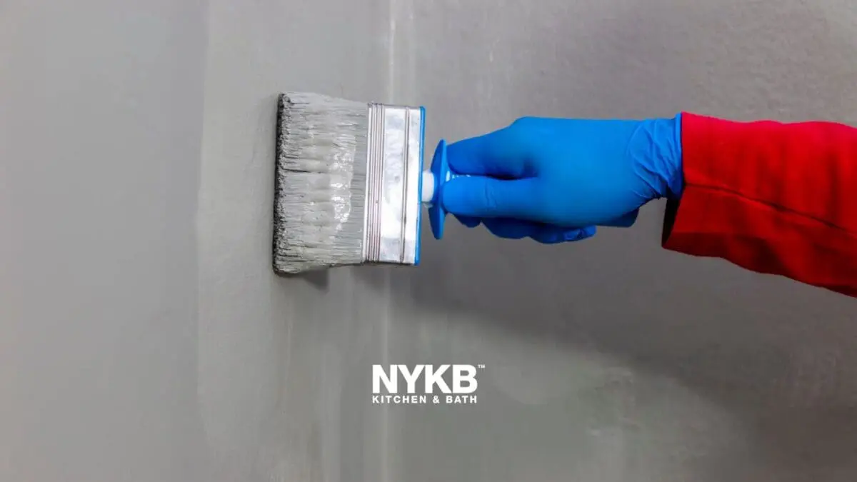 gray waterproof paint for bathroom applied by worker on the wall 