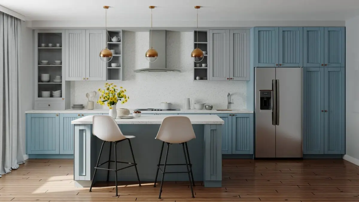 Modern kitchen featuring two-tone cabinets with soft gray upper cabinets and muted blue lower cabinets, complemented by a terrazzo countertop, warm wood flooring, stainless steel appliances, and pendant lighting for a stylish and inviting atmosphere.